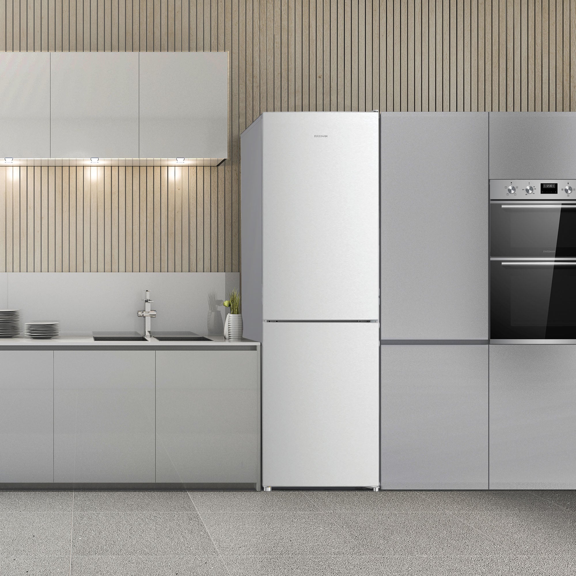 Modern kitchen with light gray cabinets, a Statesman v60/40 Low Frost Fridge Freezer in White by Statesman Appliances, built-in oven, sink, stovetop, and dishes on the counter. The wall features vertical wooden slats and under-cabinet lighting, while adjustable shelving ensures flexible storage options.