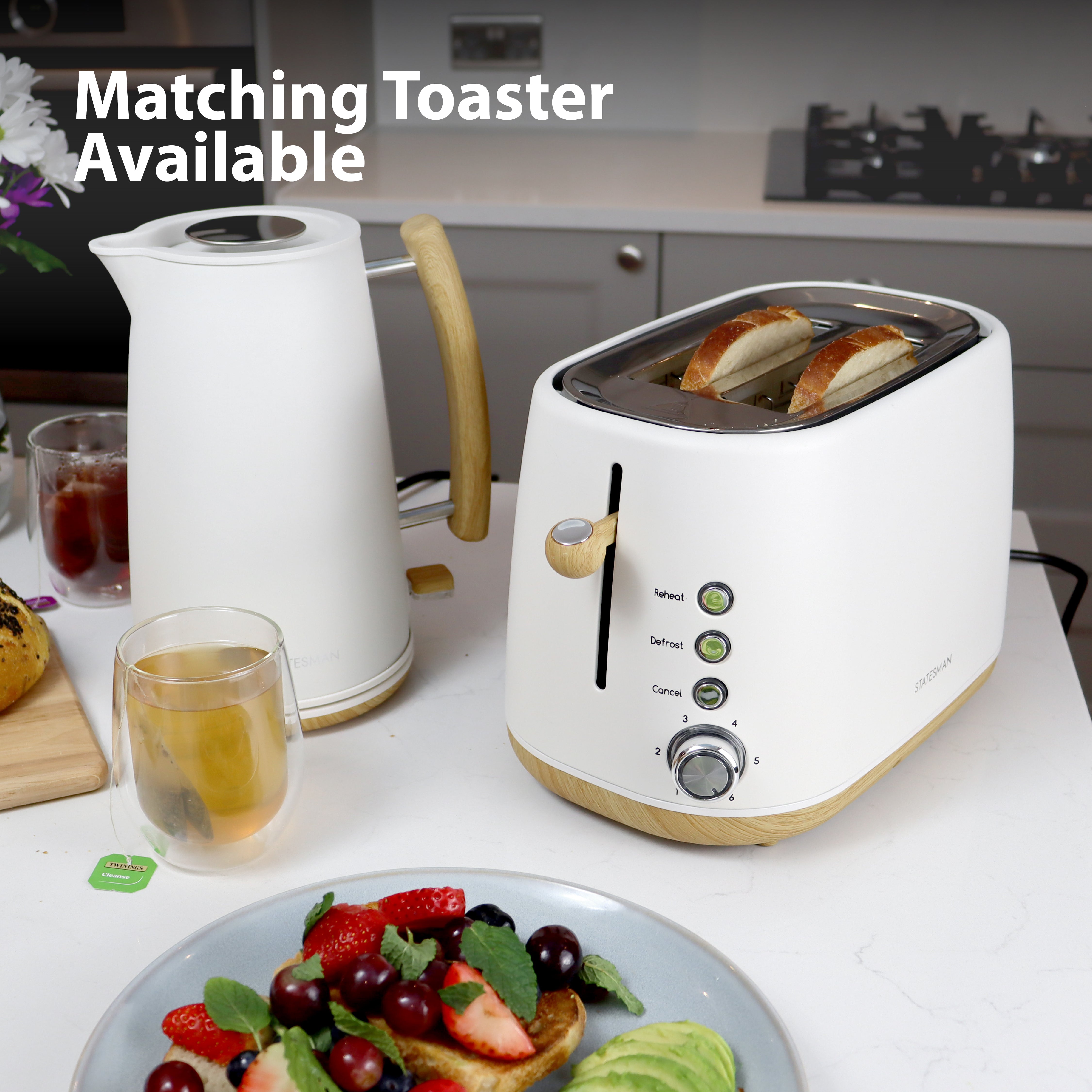 A Statesman 1.7L Scandi Kettle with cordless base sits on the counter next to a white toaster with two slices of bread, tea, and fruit. "Matching Toaster Available" text appears top left. Rapid boil for convenience. Brand: Statesman Appliances.
