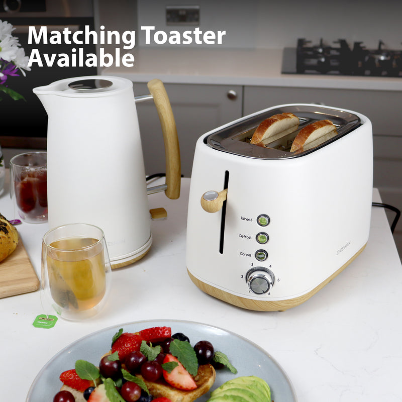A Statesman 1.7L Scandi Kettle with cordless base sits on the counter next to a white toaster with two slices of bread, tea, and fruit. "Matching Toaster Available" text appears top left. Rapid boil for convenience. Brand: Statesman Appliances.
