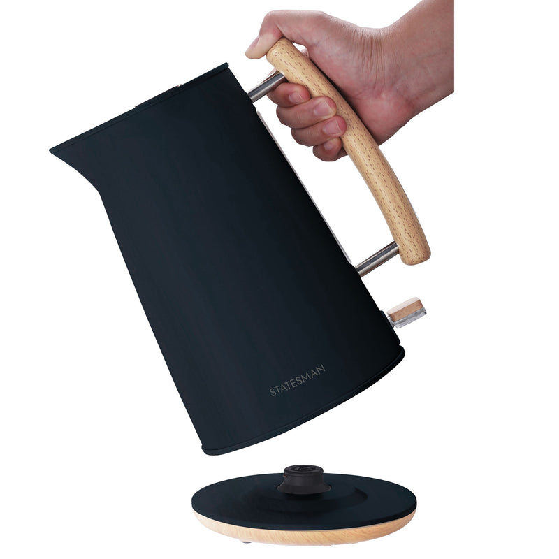 A hand holds the Statesman 1.7L Scandi Kettle with a wooden handle above its cordless base, showcasing the Statesman Appliances logo and the kettle's sleek 3000W design.